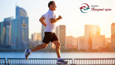 Мужчина бегает оп набережной на рассвете